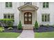 Close-up of the home's entry way featuring decorative front doors, stone facade, and manicured landscaping at 1400 Squire Ln, Cumming, GA 30041