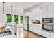 Gourmet kitchen featuring white cabinets, stainless appliances, and backyard views at 1400 Squire Ln, Cumming, GA 30041