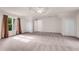 Large carpeted main bedroom features tray ceiling, ceiling fan, and neutral color palette at 1400 Squire Ln, Cumming, GA 30041
