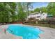 View of backyard featuring a pool and the house with a deck overlooking the landscaped yard at 1400 Squire Ln, Cumming, GA 30041