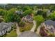 Stunning aerial view of a home with a circular driveway, mature trees, and beautifully landscaped grounds at 2049 Kinderton Manor Dr, Johns Creek, GA 30097