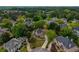 Expansive aerial view showcasing a beautiful home on a large, wooded lot within a serene neighborhood at 2049 Kinderton Manor Dr, Johns Creek, GA 30097
