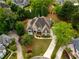 Captivating aerial view of an estate featuring manicured lawns, mature trees, and a circular driveway at 2049 Kinderton Manor Dr, Johns Creek, GA 30097