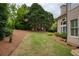 Lush green backyard featuring well-maintained lawn and mature trees, creating a private oasis at 2049 Kinderton Manor Dr, Johns Creek, GA 30097
