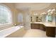 Elegant bathroom with soaking tub, glass shower and decorative arched window at 2049 Kinderton Manor Dr, Johns Creek, GA 30097