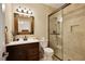 Modern bathroom with dark wood vanity, quartz countertop, framed mirror, and glass enclosed shower at 2049 Kinderton Manor Dr, Johns Creek, GA 30097