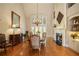 Elegant dining room with hardwood floors, chandelier, fireplace, and large windows offering ample natural light at 2049 Kinderton Manor Dr, Johns Creek, GA 30097