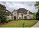 Beautifully landscaped two-story home with manicured lawn and elegant architectural details at 2049 Kinderton Manor Dr, Johns Creek, GA 30097