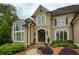 Close up of a home with well-manicured landscaping, stone pathway, and arched entryway at 2049 Kinderton Manor Dr, Johns Creek, GA 30097