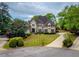 Stunning two-story home boasts a manicured lawn and a circular driveway at 2049 Kinderton Manor Dr, Johns Creek, GA 30097