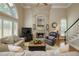 Bright living room with large windows, a fireplace, and comfortable seating, creating a cozy atmosphere at 2049 Kinderton Manor Dr, Johns Creek, GA 30097