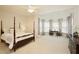 Spacious main bedroom featuring a four-poster bed, sitting area with large bay window, and a ceiling fan at 2049 Kinderton Manor Dr, Johns Creek, GA 30097
