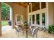 Inviting covered patio featuring an outdoor dining area, glass doors, and a view of the landscaped backyard at 2049 Kinderton Manor Dr, Johns Creek, GA 30097