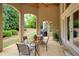 Inviting covered patio featuring an outdoor dining area, glass doors, and a view of the landscaped backyard at 2049 Kinderton Manor Dr, Johns Creek, GA 30097