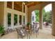 Inviting covered patio featuring an outdoor dining area, glass doors, and a view of the landscaped backyard at 2049 Kinderton Manor Dr, Johns Creek, GA 30097