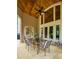 Inviting covered patio featuring an outdoor dining area, glass doors, and a view of the landscaped backyard at 2049 Kinderton Manor Dr, Johns Creek, GA 30097
