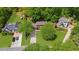Aerial view showing a well-kept lawn and long driveway leading to a brick home nestled among mature trees at 2700 Sandstone Dr, Lawrenceville, GA 30043