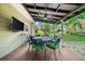 Inviting back porch featuring a table with chairs, outdoor lighting, and a view of the garden at 2700 Sandstone Dr, Lawrenceville, GA 30043