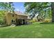 Expansive backyard featuring a covered patio, lush green lawn, and mature trees offering shade at 2700 Sandstone Dr, Lawrenceville, GA 30043