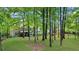 Spacious green backyard is surrounded by mature trees, the house and a garden area beyond at 2700 Sandstone Dr, Lawrenceville, GA 30043
