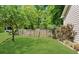 Lush, green backyard features a charming wooden fence, vibrant roses, and mature trees providing privacy at 2700 Sandstone Dr, Lawrenceville, GA 30043