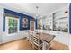Sunlit dining area with blue accent wall, built-in shelving, hardwood floors, and modern chandelier at 2700 Sandstone Dr, Lawrenceville, GA 30043