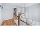 Upstairs hallway with hardwood flooring, decorative lighting and white trim leading to bedrooms at 2700 Sandstone Dr, Lawrenceville, GA 30043