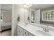 Modern bathroom with double vanity, large mirror, and adjacent bathtub and toilet room at 2995 Boulder Walk Se Ct, Atlanta, GA 30316