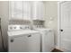 Functional laundry room featuring a washing machine, dryer, and storage cabinet at 2995 Boulder Walk Se Ct, Atlanta, GA 30316