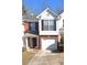 Charming two-story townhouse features a brick and white facade, black shutters, and attached garage at 3777 Harvest Dr, Decatur, GA 30034