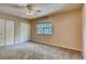 Carpeted bedroom features a ceiling fan, natural light, and double closets at 6593 Sleepy Hollow Ln, Morrow, GA 30260