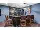 Chic basement bar area boasts dark wood accents, modern shelving, and comfortable seating for entertaining at 101 Fernwood Dr, Woodstock, GA 30188
