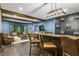 Home bar, adjacent to the living area, with custom bar and plenty of seating for entertaining guests and Gathering at 101 Fernwood Dr, Woodstock, GA 30188