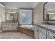 Elegant bathroom with a soaking tub under a window, dual vanities, and granite countertops at 101 Fernwood Dr, Woodstock, GA 30188
