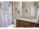 Charming bathroom featuring a granite countertop vanity, decorative floral shower curtain, and unique wall art at 101 Fernwood Dr, Woodstock, GA 30188
