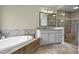 Bright bathroom featuring a soaking tub, granite countertop vanity, and glass shower at 101 Fernwood Dr, Woodstock, GA 30188