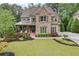 Charming two-story home with a stone facade, lush landscaping, and a welcoming front porch at 101 Fernwood Dr, Woodstock, GA 30188