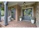 Inviting front porch with brick flooring, decorative columns, and stylish outdoor decor at 101 Fernwood Dr, Woodstock, GA 30188
