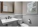 Chic half bath with pedestal sink, white wainscoting, and a classic framed mirror at 101 Fernwood Dr, Woodstock, GA 30188