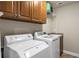 Bright laundry area with washer, dryer, built-in cabinets, sink, and wire shelving for storage at 101 Fernwood Dr, Woodstock, GA 30188