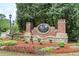 Fernwood Creek entrance sign with brick and stone, complemented by colorful flowers and greenery at 101 Fernwood Dr, Woodstock, GA 30188