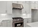 Close up view of the stylish white kitchen cabinetry, tiled backsplash and stainless steel stove at 1420 Coretta Bnd, Atlanta, GA 30318