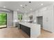 Modern kitchen showcasing an island with quartz countertops, white cabinets, stainless steel appliances, and hardwood floors at 1420 Coretta Bnd, Atlanta, GA 30318