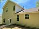 Home's back exterior featuring tan siding, multiple windows, and a door at 3432 Sumter Pl, Decatur, GA 30034