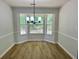 Dining area featuring wood floors, wainscoting and a modern chandelier at 3432 Sumter Pl, Decatur, GA 30034