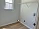 Bright laundry room with wood-look flooring, utility sink, and storage shelf at 3432 Sumter Pl, Decatur, GA 30034