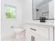 Bathroom featuring a new vanity, commode, and a peek into the marble tiled shower at 4215 Sherwood Ave, Decatur, GA 30035