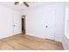 Neutral bedroom featuring hardwood floors, with a ceiling fan, white walls, and an interior door to another room at 4215 Sherwood Ave, Decatur, GA 30035