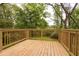 New backyard wooden deck showcases beautiful natural outdoor surroundings and a wooden safety rail at 4215 Sherwood Ave, Decatur, GA 30035