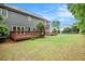Spacious backyard with wood deck and a view of the multi-level screened porch and lush green grass at 732 Sweet Gum Way, Canton, GA 30115